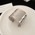 Detail of silver textured wide cuff bracelet with hammer pattern on white ceramic - Bracelet-Pleated Style / Silver