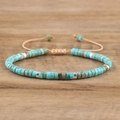 Macro-opname van turquoise kralen met zilveren afstandhouders op verstelbare geweven armband - 4 Cyaan getextureerde steen