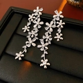 Makroansicht langer Quastenohrringe mit klaren Zirkonblumen auf schwarzem Tablett - Transparent (925 Sterling Silber Ohrring Stecker)