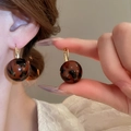 Close-up of leopard print resin ball earrings with elegant gold metal hoop closures - Gold Brown Black Ball (7)