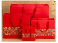 Detail of four Chinese style red paper gift bags with traditional patterns and rope handles - China Red