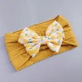 Detail of baby headband featuring ginger yellow knitted texture and floral bow detail - Ginger Yellow