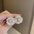 Macro detail of sunburst pearl flower earrings with large center pearl and gold alloy base - 33# White Pearl Fireworks
