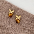 Dettaglio macro di orecchini a forma di X dorati con perle di resina marrone - Perno per orecchini in argento-Oro-Caffè