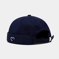Detail view of heart embroidery and adjustable metal buckle on navy brimless cap - Adjustable / Navy Blue