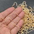 Primer plano de ganchos para pendientes dorados con bola y resorte para joyería DIY - Gancho de oreja de cruz / Oro KC