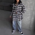 Oversized retro geruit overhemd met jeans tegen een minimalistische industriële wand - S / Zwart