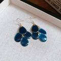 Vista detallada de los pendientes de gota azul oscuro con elegantes ganchos de metal dorado - Gancho Dorado Azul
