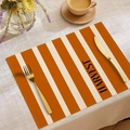Detail view of orange striped Harvest placemat with elegant gold cutlery and coffee cup - Orange Stripe HARVEST