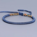 Handmade woven Vajra knot bracelet in blue with colorful accents and adjustable cord - Haze Blue with Multicolor Tail