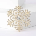 Macro shot of gold snowflake brooch with sparkling crystal rhinestones and center stone - Gold