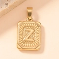 Detailed macro view of gold-plated square pendant with embossed letter Z and coin-style edges - Letter Z
