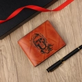 Vintage orangefarbene Lederbörse mit geprägtem Totenkopf-Design auf einem Holztisch - Hellkaffee