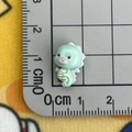 Close-up of a 1.5cm mini resin seahorse charm measured with a ruler on a cutting mat - Seahorse