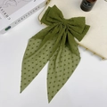 Detail of green Swiss dot fabric hair bow with long ribbons on a decorative tray - Green