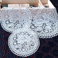 Close-up of white lace coasters with intricate rose patterns and wavy scalloped edges - 25cm / Rose