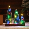 Dreiteiliges Mini-Weihnachtsbaum-Set mit bunten LED-Lichtern auf langem Holzsockel - Farbenfrohe Dreifach-Weihnachtsbäume