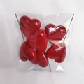 Close-up of red heart cake toppers with glossy finish and metal sticks in pack - 60mm (Pack)