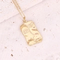 Macro view of golden rectangular pendant with an abstract face relief on a stone base - Gold Face Relief Rectangular Style (13#)