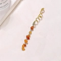 Nahaufnahme der goldenen Haarspirale mit Naturstein-Anhänger auf Marmor-Hintergrund - Orange Lang (E9107) / Orange