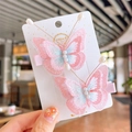 Detailed view of hand held embroidered butterfly hair clips with soft pink pearls - Pink