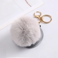 Macro view of fluffy faux rabbit fur ball keychain with mirror and golden metal clasp - Light Grey With Fur Ball