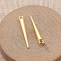 Polished gold pointed cone pendants with circular hanging loops on wooden base - Bright Gold