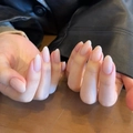 Natural nude almond press-on nails with glossy finish shown on hands in natural light - Opal Star Stone