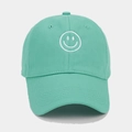 Close-up of mint green baseball cap featuring white smile embroidery on soft cotton fabric - Cyan