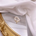 French vintage freshwater pearl ring featuring a gold cross pendant on a mirror - Letter T