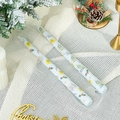 Detail of Christmas tapered candles with festive prints on white textured fabric - Christmas Berry (Light Blue)