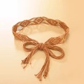 Detail of khaki woven ethnic belt with brown beads and long tassels on beige background - Camel