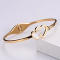 Macro detail of gold double-heart bangle with shell inlay and zirconia on stone - Shell Heart Bangle / Gold