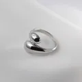 Polished silver liquid metal ring in minimalist droplet wrap design on white fabric - Adjustable Open / Water Drop Platinum