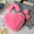 Detail view of heart-shaped faux fur plush bag in pink with gold chain and furry pompom charms - Bright Pink