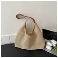 Detail van handgeweven beige stro hobo tas met bruine lederen bies en halfmaan silhouet - Bruin