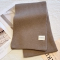 Brown rib-knit scarf in wool blend with h.nolamduo tag on soft textured background - Apricot Grey