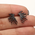 Irregular branch-shaped stainless steel earrings in matte black finish held by hand - Tree Branch / Black