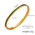 Detailed close-up of a titanium steel bracelet with green square glass drill inlay - Gold Green Zirconia Bangle