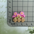 Vue macro d'un accessoire barrière fleurie en résine avec règle de mesure - Clôture de Fleurs Rose Vif