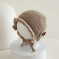 Detail of baby knit hat showing soft brown yarn texture and cream ruffled edges - 6-24 Months / Brown