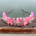 Detailed view of a pink crystal crown with metal moon and star accents on wood - Peach Pink