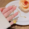 Goldene Halskette mit Hasenkopf-Anhänger auf weißem Keramikteller mit rosa Rosen - X660 Gold Hase Anhänger