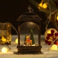 Beleuchtete goldene Weihnachtslaterne mit Rentierfigur und verschneiten Tannen - Flache Lampe Rentier Modell