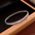 Détail d'un bracelet vintage en argent avec pierres pavées sur un support en velours - Jonc Zirconia Dentelé Argent