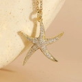 Starfish pendant necklace with white zircons and gold plating on a jewelry stand - White Zirconia Starfish