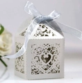 Close-up of white laser-cut heart pattern wedding favor box with a blue ribbon bow - Silver Grey