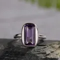 Macro shot of emerald-cut natural amethyst ring on grey stone, 925 silver band - Four-prong Minimalist Style (LR279)