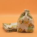 Linen drawstring pouch with colorful butterfly and birdcage print on orange background - Birdcage