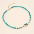 Detail of turquoise beaded necklace featuring a gold Yoga pendant and lobster clasp - Blue Turquoise Style (YOGA/Blue Enamel)
